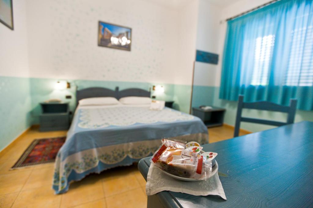 a bedroom with a bed and a table with shoes on it at History Hotel in Valderice