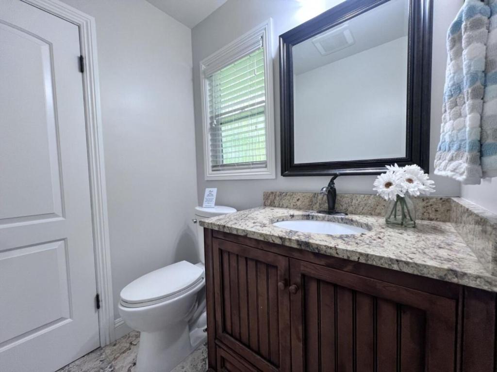 a bathroom with a sink and a toilet and a mirror at Sweet 5 Bedroom, 4 Bath Pool Home 1/2 Mile Walk To Disney in Anaheim