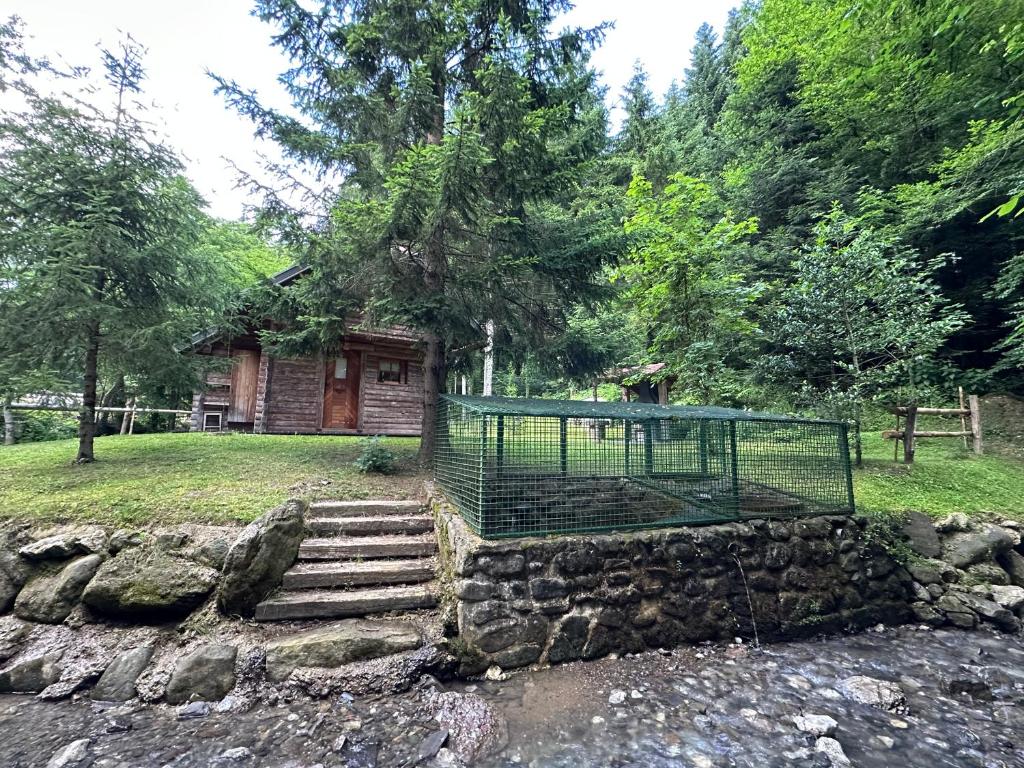 a cage on a stone wall in front of a house at Hiška ob potočku in Ljubno