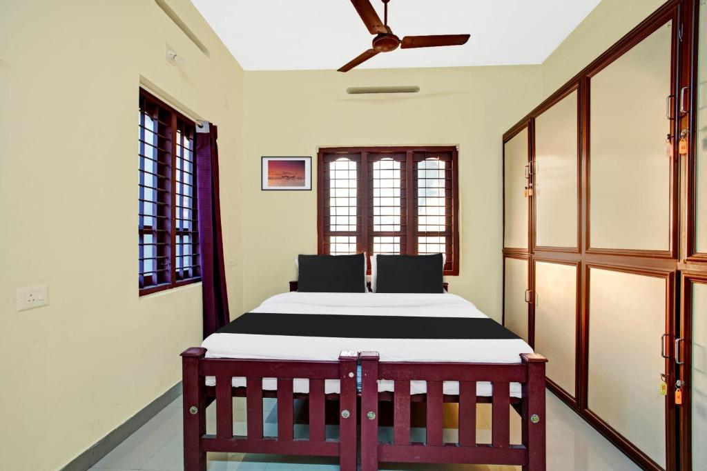 a bedroom with a bed and a ceiling fan at Hotel O Nakshathra Inn in Kazhakuttam