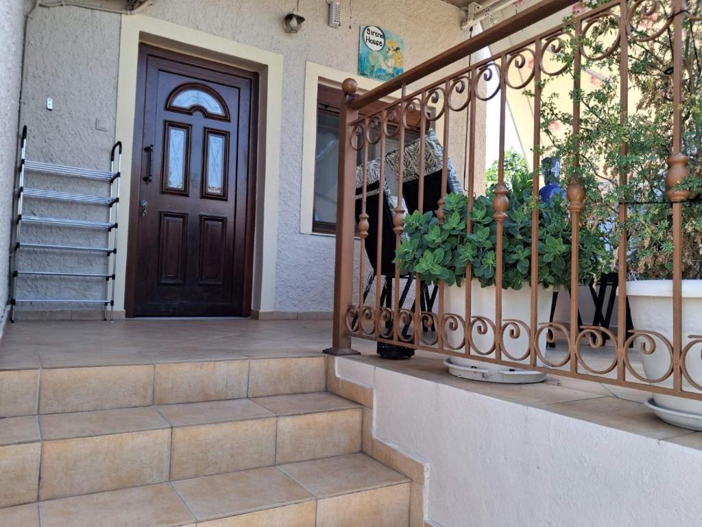a front door of a house with plants on a porch at Sirena House in Limenaria