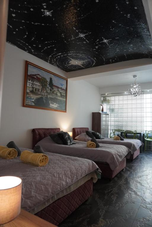 a room with three beds and a ceiling with stars at Penelopa Apartments in Ohrid