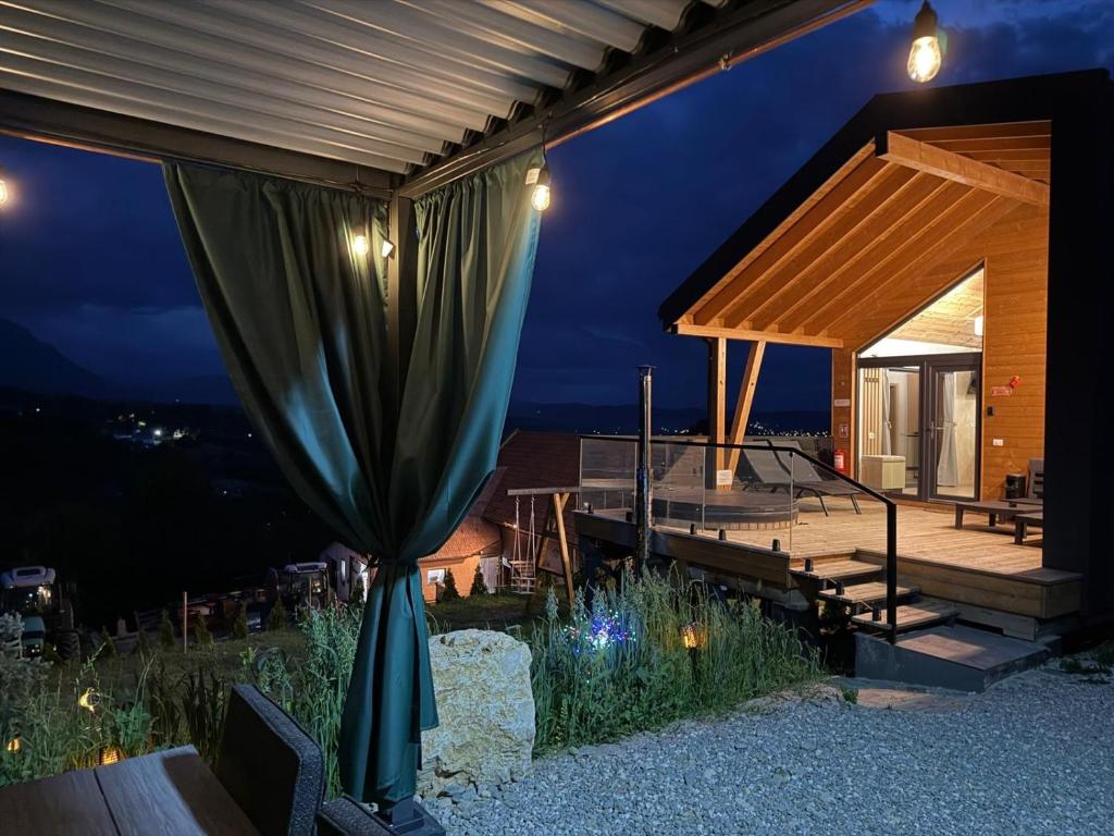 a house with a large green curtain on a patio at Royal Hill Bran-A-Frame and Bungalows whit Hot Tub and Sauna in Sohodol