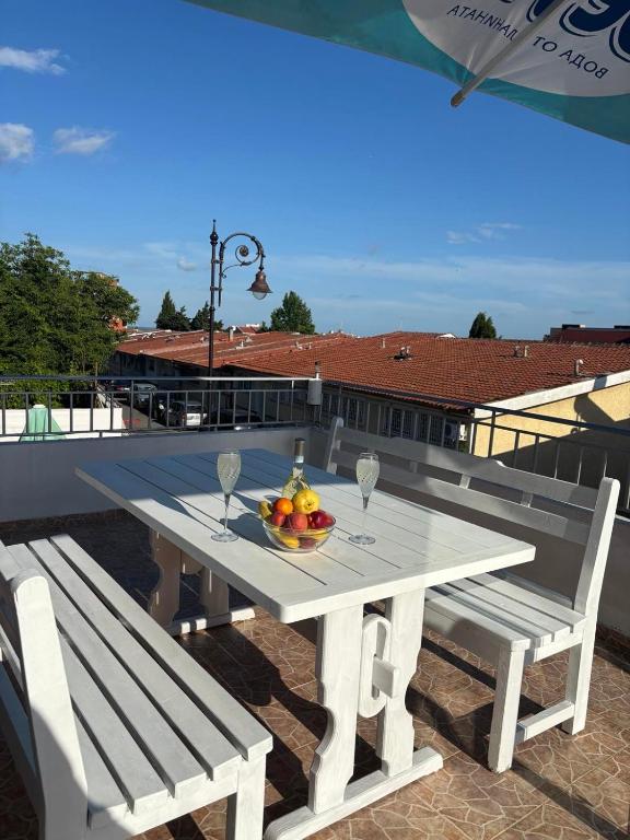 a white table with two chairs and a bowl of fruit at Апартамент Енигма in Sveti Vlas
