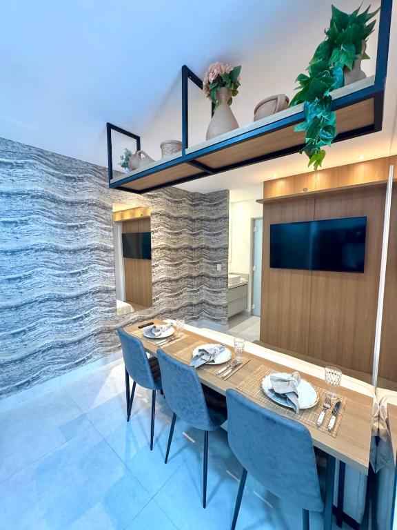 a dining room with a wooden table and blue chairs at Infinity 1206 - 2 Quartos a Passos da Praia com Garagem in Vila Velha