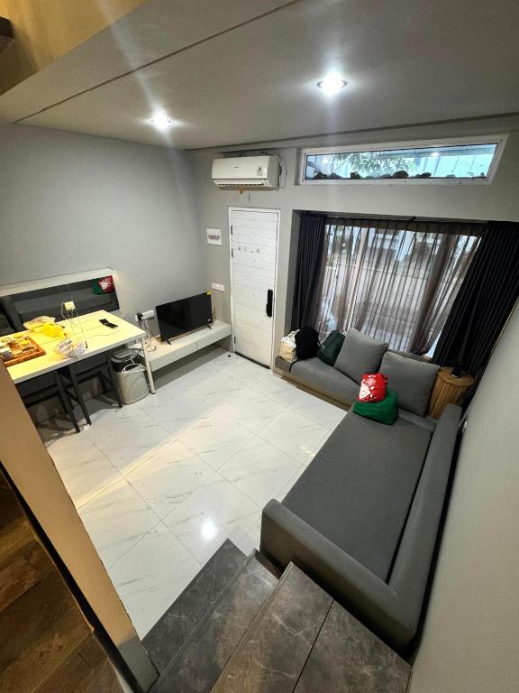 an empty living room with a couch and a desk at Comfortable House - Tabebuya BSD in Tegal