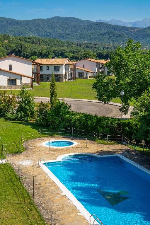 a large swimming pool in a yard with houses at Casas Green Ordesa in Aínsa