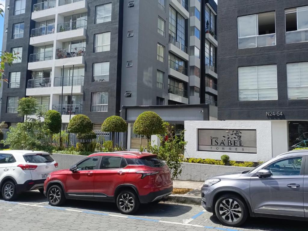 three cars parked in a parking lot in front of a building at Like a Home - 2Bedrooms - QueenBed - Balcony - Parking - 7Th FLOOR in Quito