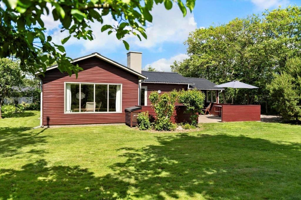 a small red house with a grass yard at BV310-Blavand-Gronnevej-16 in Blåvand