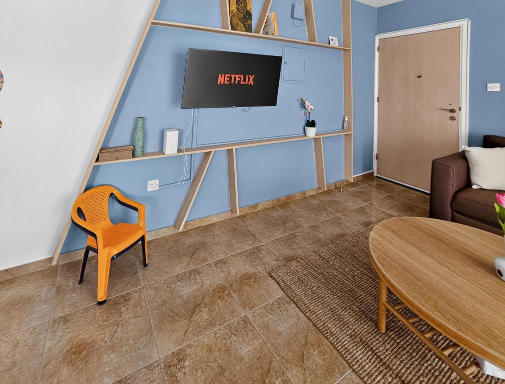 a living room with a tv and a couch and a table at Rest Studio 6 in Sotira