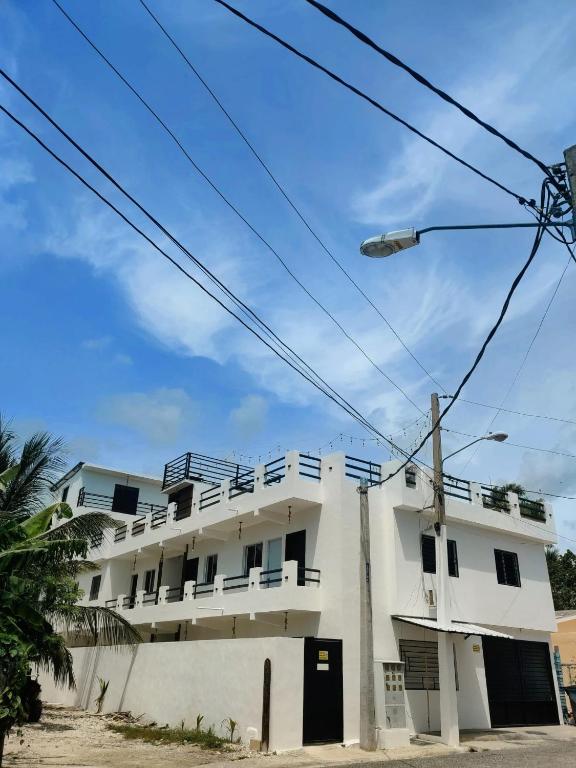 a white apartment building with a street light at Macao Sky pool suites in Punta Cana