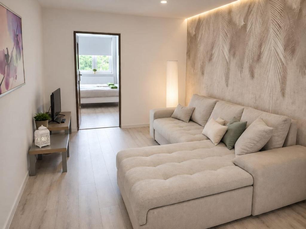 a living room with a couch and a table at Pokoje nad Welem Lidzbark in Lidzbark