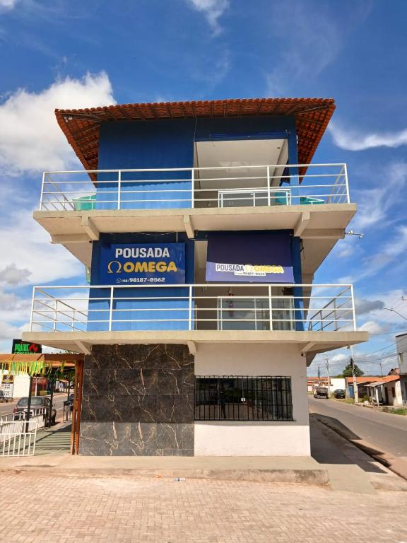 a blue and white building with a sign on it at Pousada Ômega in Caxias das Aldeias Altas