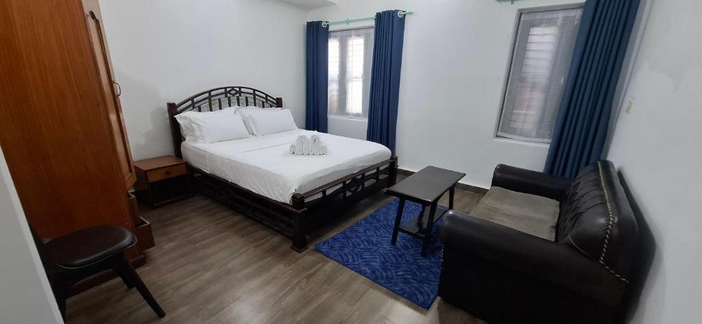 a bedroom with a bed and a chair and a couch at Square Accommodation Rudra kunj in Pokhara