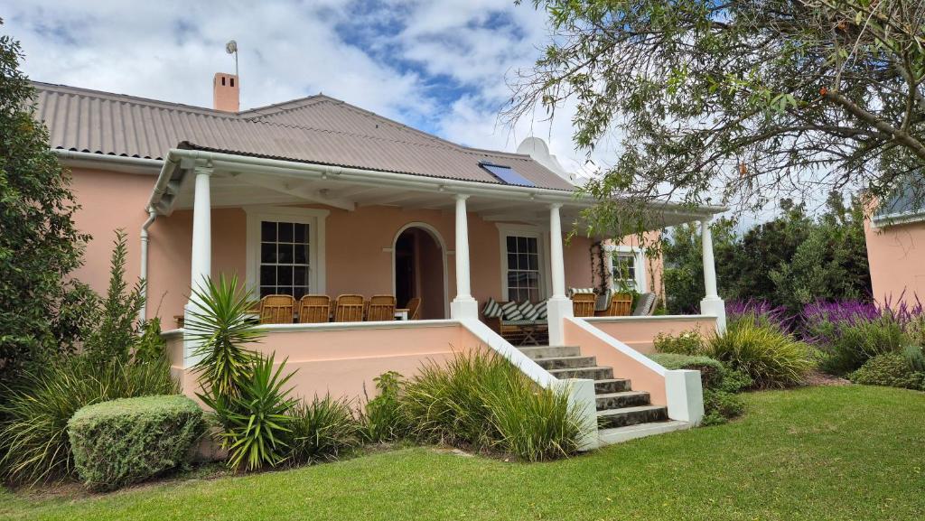 a pink house with a porch and stairs at Stanford Villa in Stanford