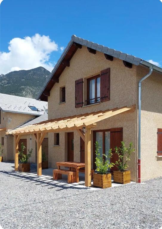 a building with a picnic table in front of it at Le Pré Fleuri à Guillestre - Appartements neufs classés Meublés de Tourisme 3 étoiles- Climatisés- Parking privatif in Guillestre
