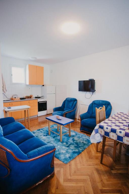 ein Wohnzimmer mit zwei blauen Sofas und einem Tisch in der Unterkunft Vikendica Nik in Bogutovac