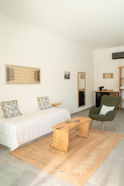 a room with a bed and a table and a chair at Thyme Suite in Paránimfoi