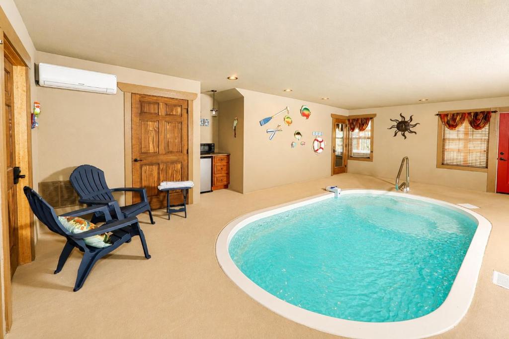 a large pool in a room with a table and chairs at Luxury Chalet w Indoor Pool, Theater Room & Game Loft — 4 Miles to Gatlinburg in Gatlinburg