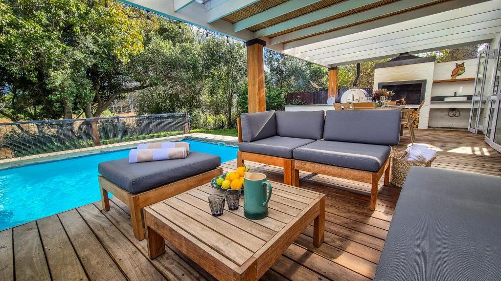 a patio with two chairs and a table next to a pool at Riverside Cottage in Stanford