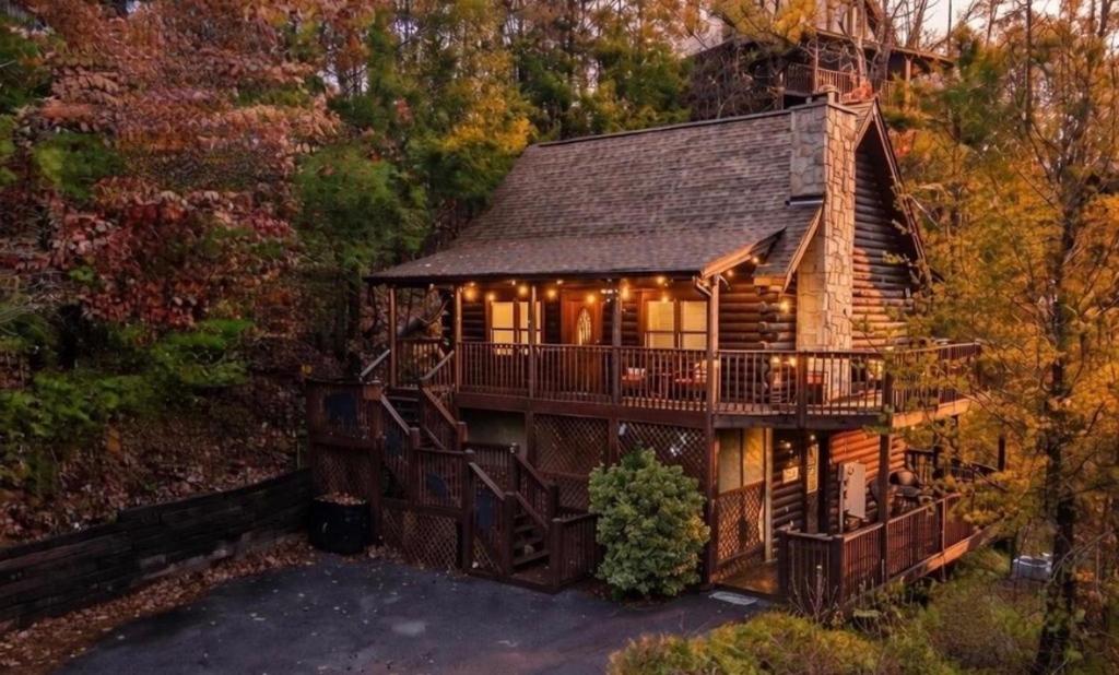 a cabin in the woods with a deck at Bearadise Hot Tub 6 Min to The Island in Pigeon Forge