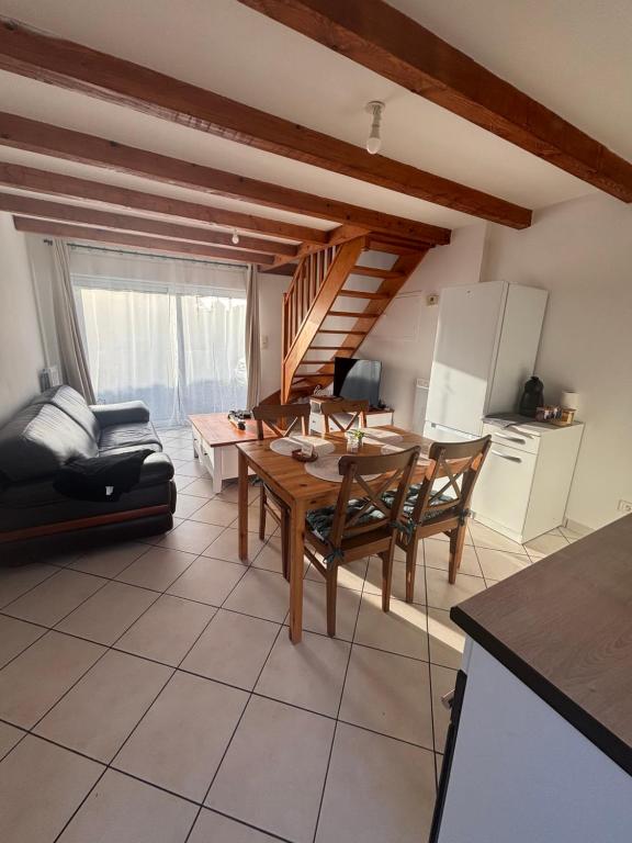 a kitchen with a table and chairs in a room at Maison près de la mer in Yffiniac
