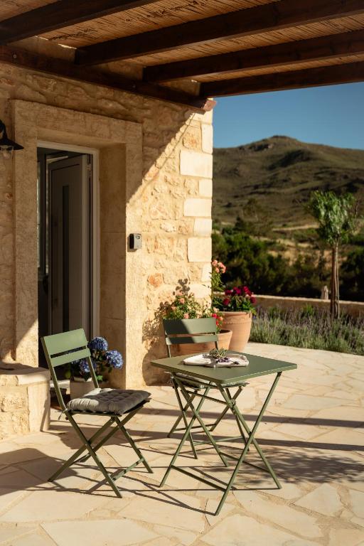 a patio with a table and two chairs in front of a building at Lavender Suite in Paránimfoi