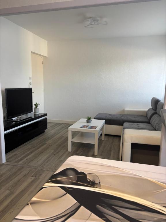 a living room with a couch and a table at Appartement Montalieu in Montalieu-Vercieu
