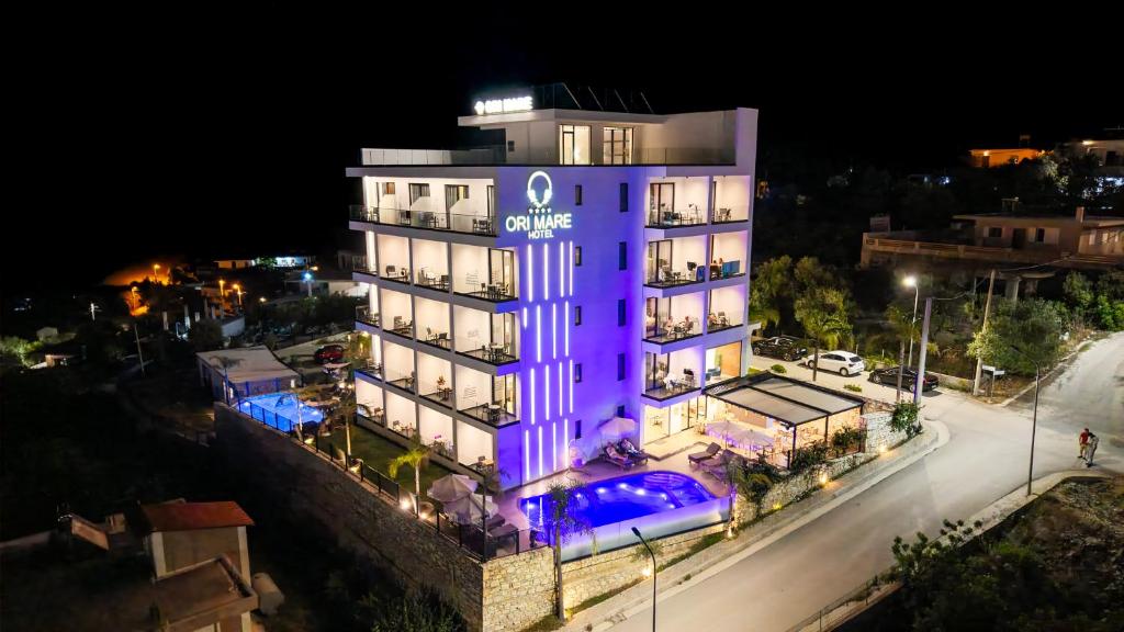 a building with purple lights on it at night at Ori Mare Hotel in Ksamil