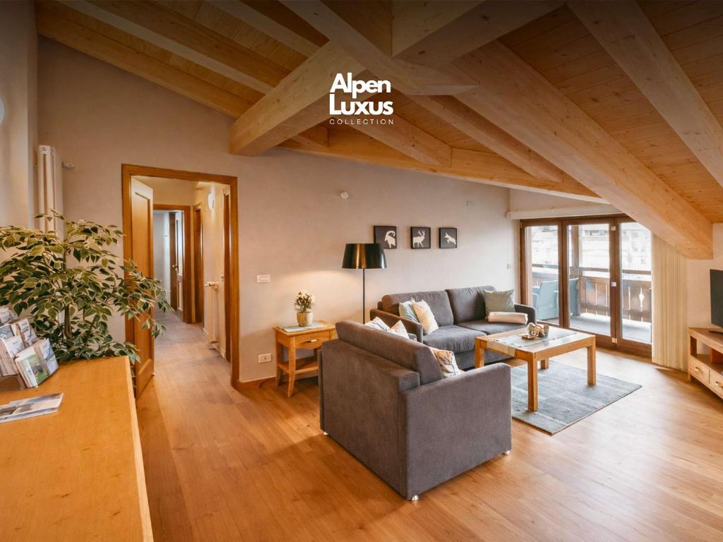 a living room with a couch and a table at ALPENNEST - Balcony & Sauna Access in Seefeld in Tirol