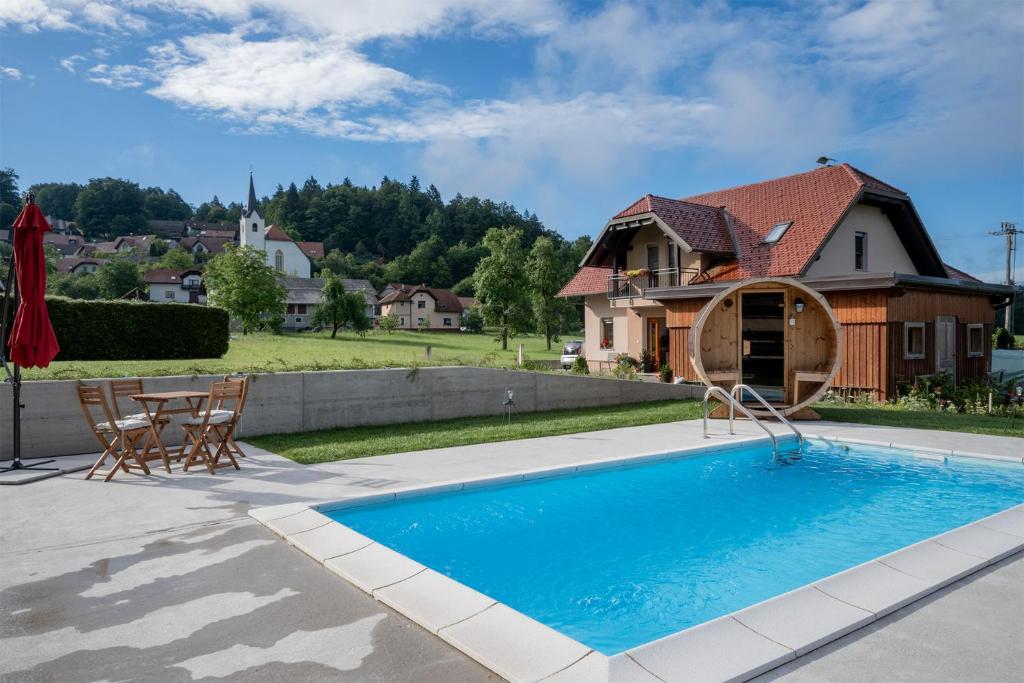 a house with a swimming pool in front of a house at Apartments Bukor with seasonal pool in Lukovica pri Domžalah