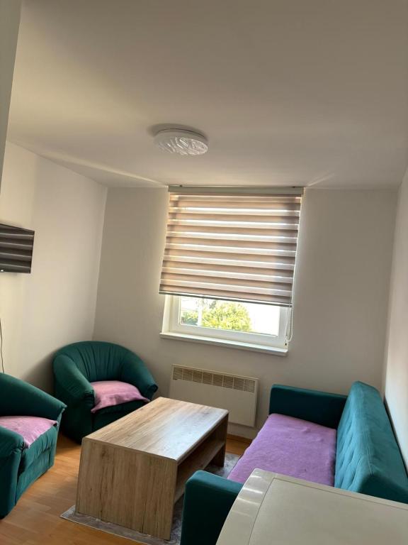a living room with a couch and a table and a window at Apartment Lamele Bugojno in Bugojno