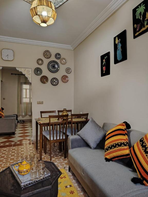ein Wohnzimmer mit Sofa und Tisch in der Unterkunft PalmRest in Marrakesch
