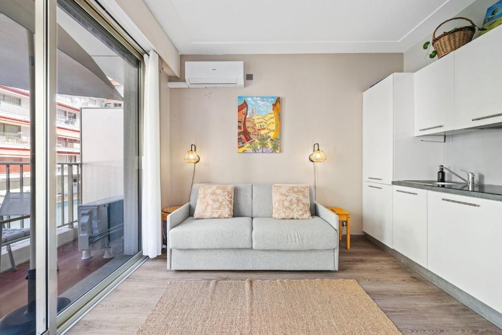 a living room with a couch and a kitchen at La Plage - Studio - Face à la Mer - Clim Terrasse in Menton