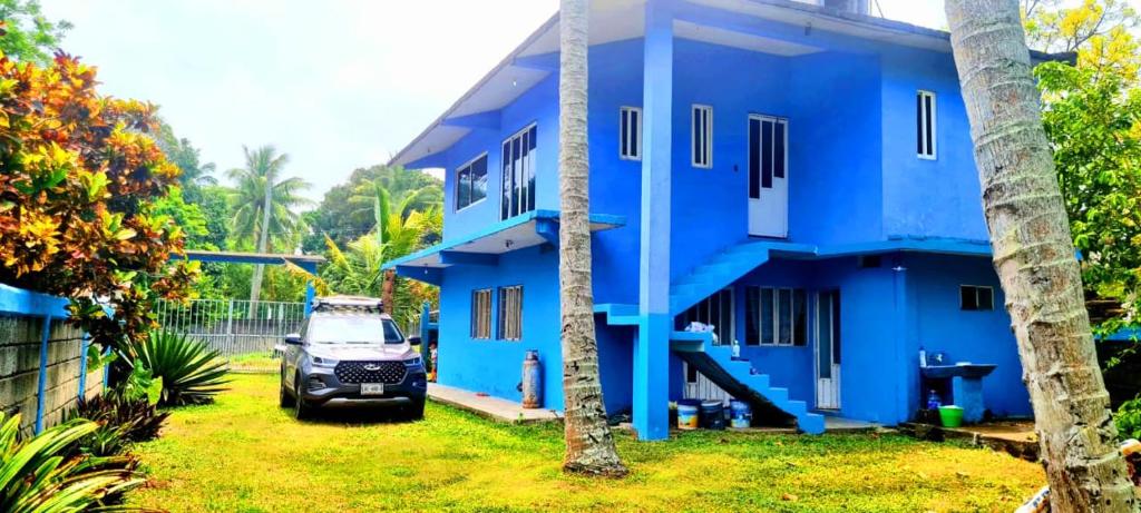 a blue house with a car parked in front of it at Casa de Descanso - Camelia in Monte Gordo