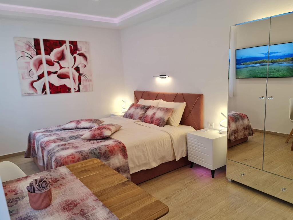 a bedroom with a bed and a table and a mirror at Getaway Pri Kobalu in Vipava