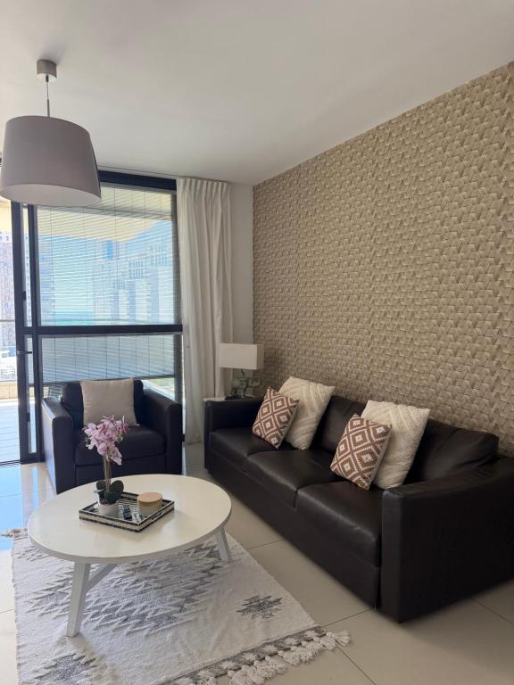 a living room with a couch and a table at appartement privé exceptionnel in Netanya