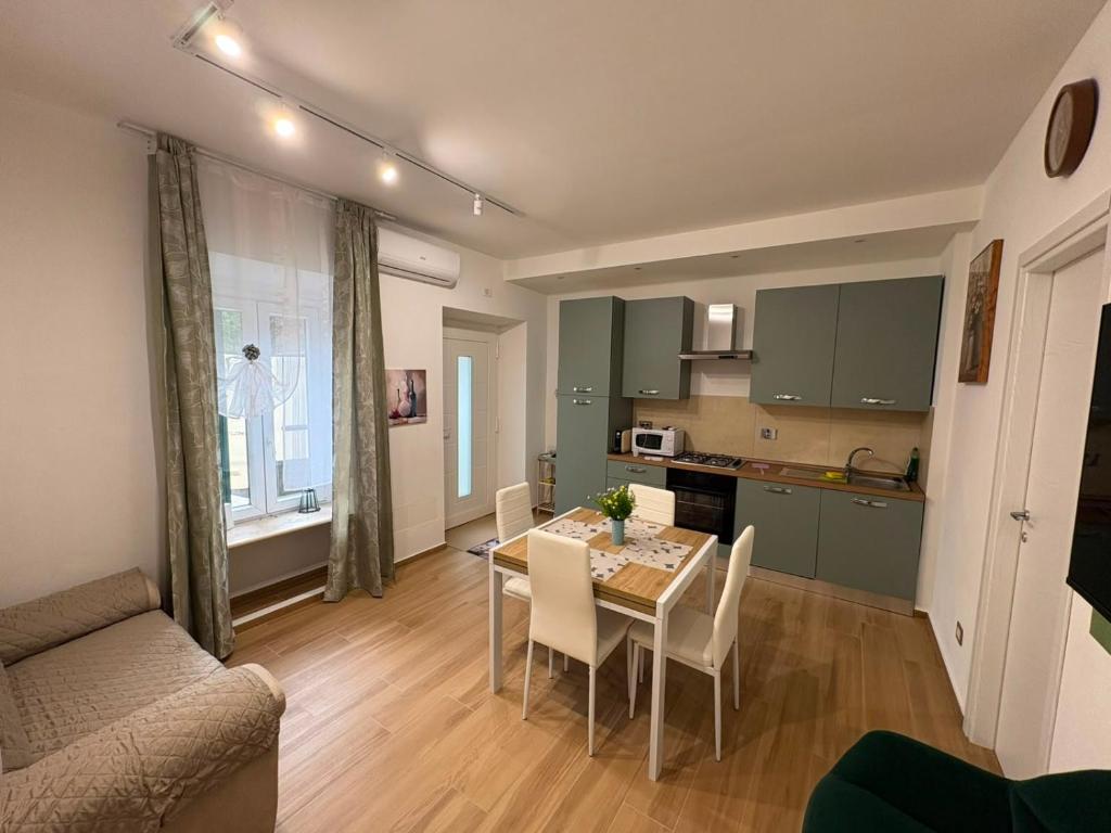 a kitchen and a dining room with a table and chairs at ADA City Apartment in Palestrina