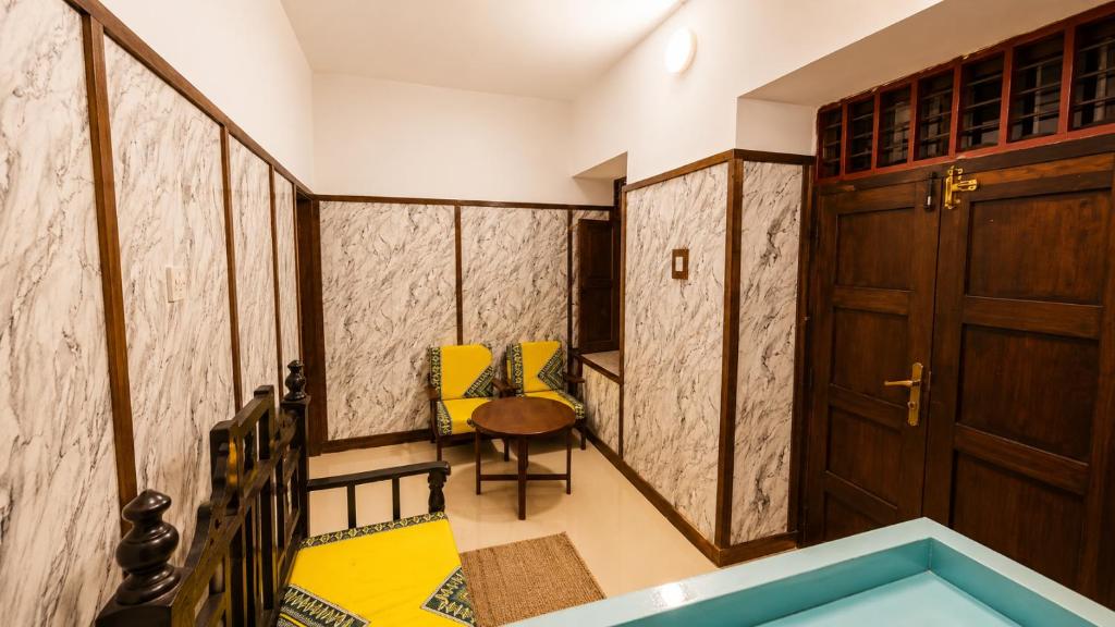 a room with two yellow chairs and a door at Serene Abodes in Zanzibar City