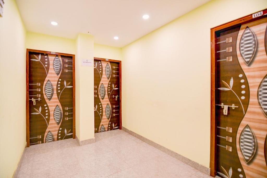 a room with three doors with wood panels at Hotel O New Star Guest House in Behāla