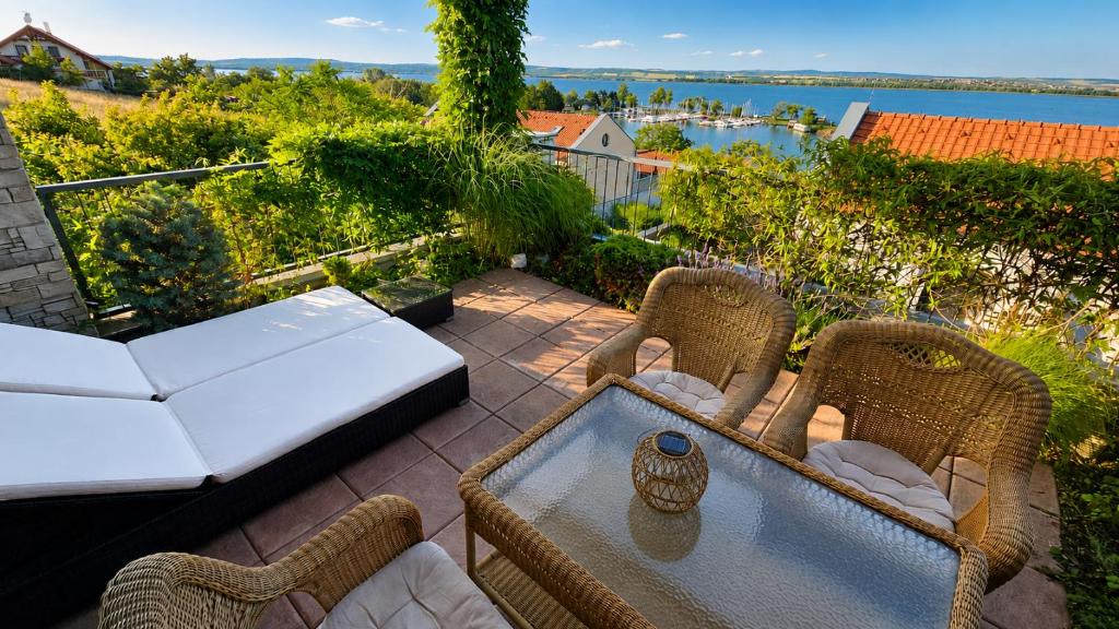 a patio with two wicker chairs and a table at Apartmán Pálava 1 s terasou a výhledem na jezero in Pavlov
