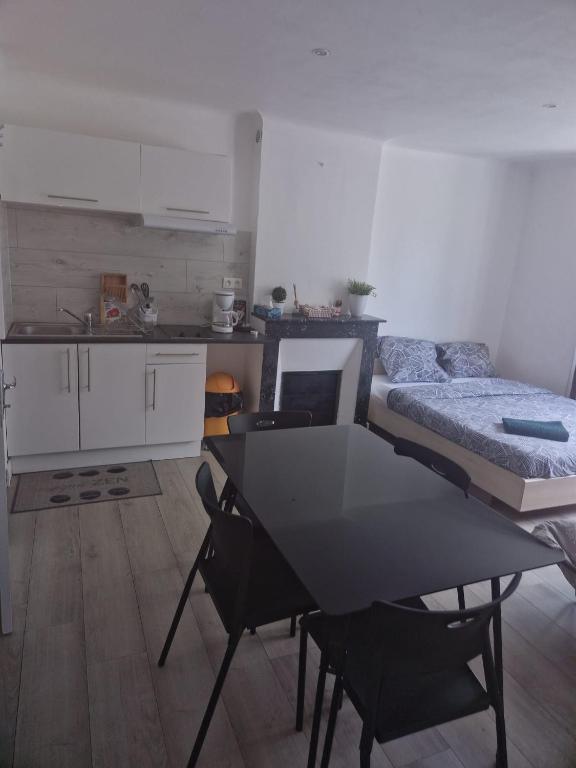 a kitchen with a table and a bed in a room at Studio la Romagne in La Romagne