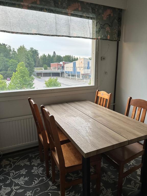 a wooden table and chairs in a room with a window at Kätevä Koti Keskustassa in Ähtäri