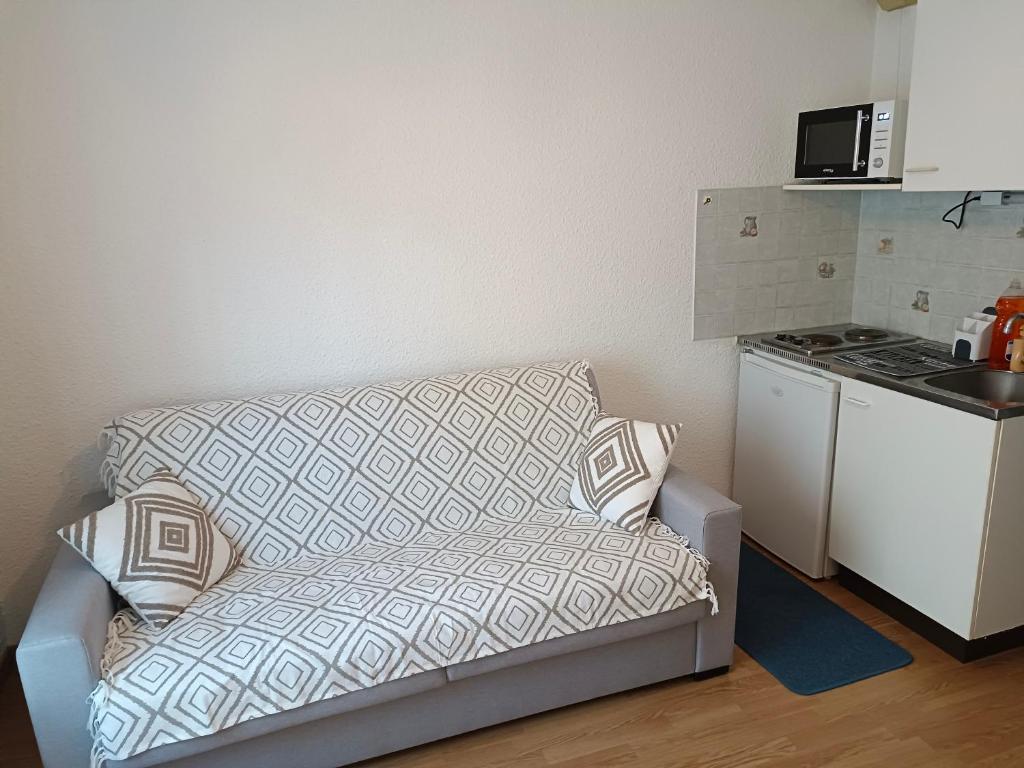 a living room with a couch in a kitchen at Studio PARAY CENTRE LOGIS 12 in Paray-le-Monial