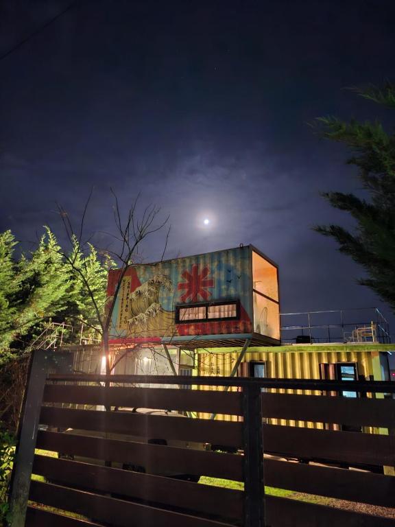 a building with graffiti on the side of it at night at CASA CONTAINER BOSQUE Y MAR in Mar del Plata