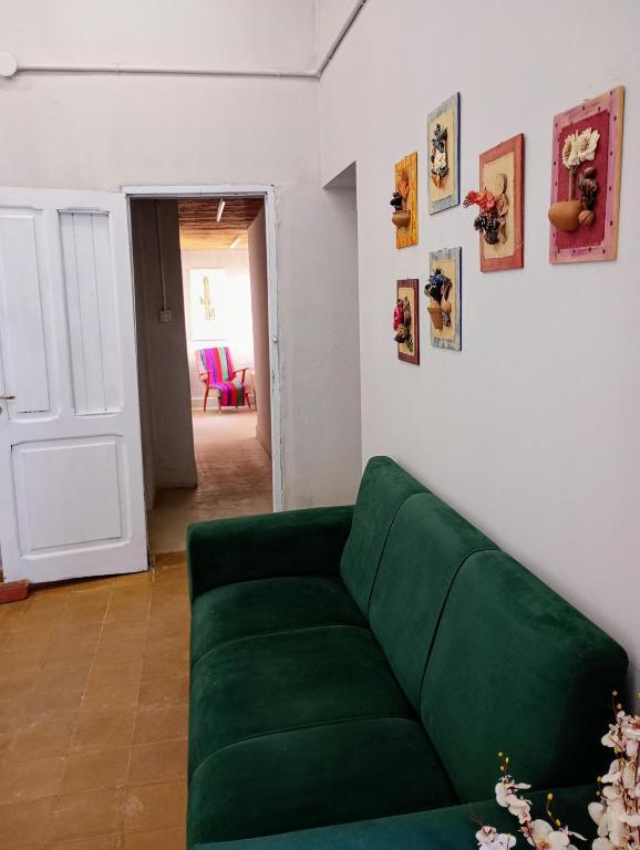 a green couch in a living room with a door at Hogar en el corazón de Tilcara in Tilcara