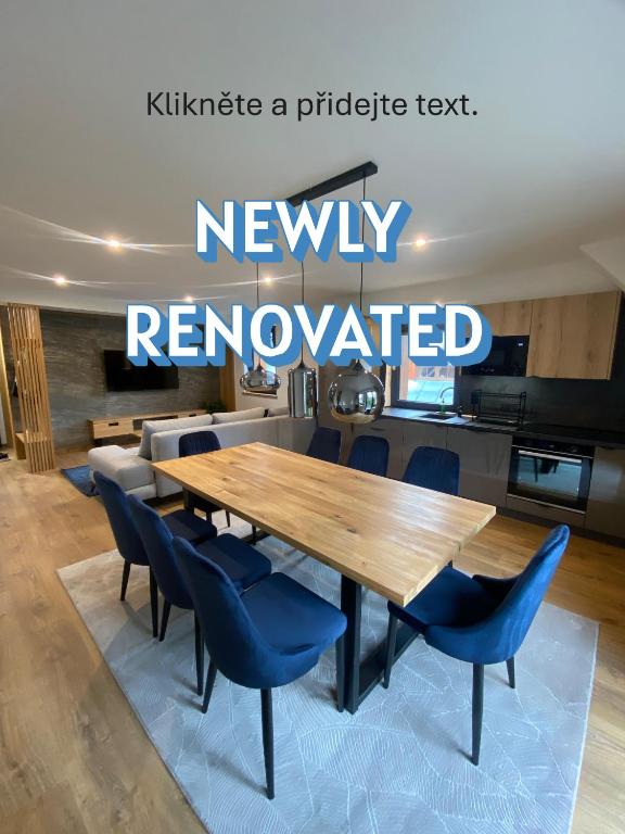 a kitchen with a wooden table and blue chairs at Apartmány La Torretta in Harrachov