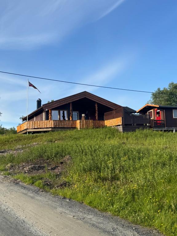 a house on the side of a grass field at Øse Camping in Gratangen