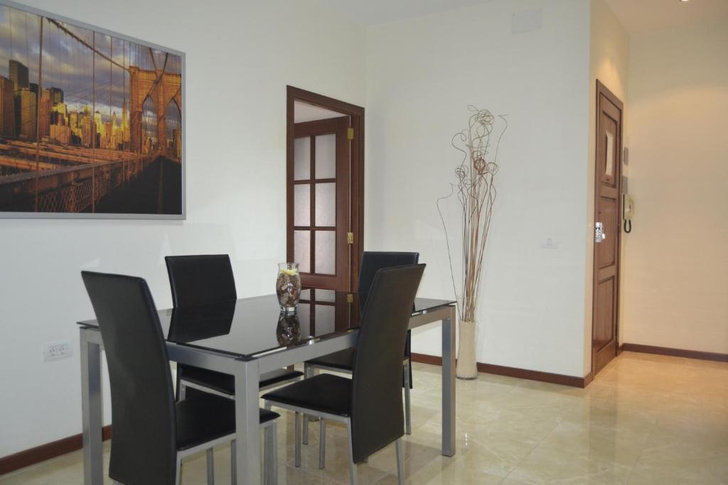 a dining room with a table and black chairs at Urban Flat in Santa Cruz de Tenerife