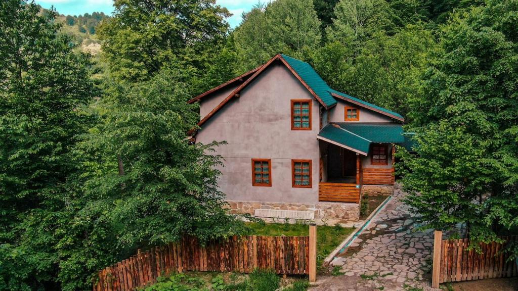 a house with a fence in front of it at Cabana La Urși in Ceraşul